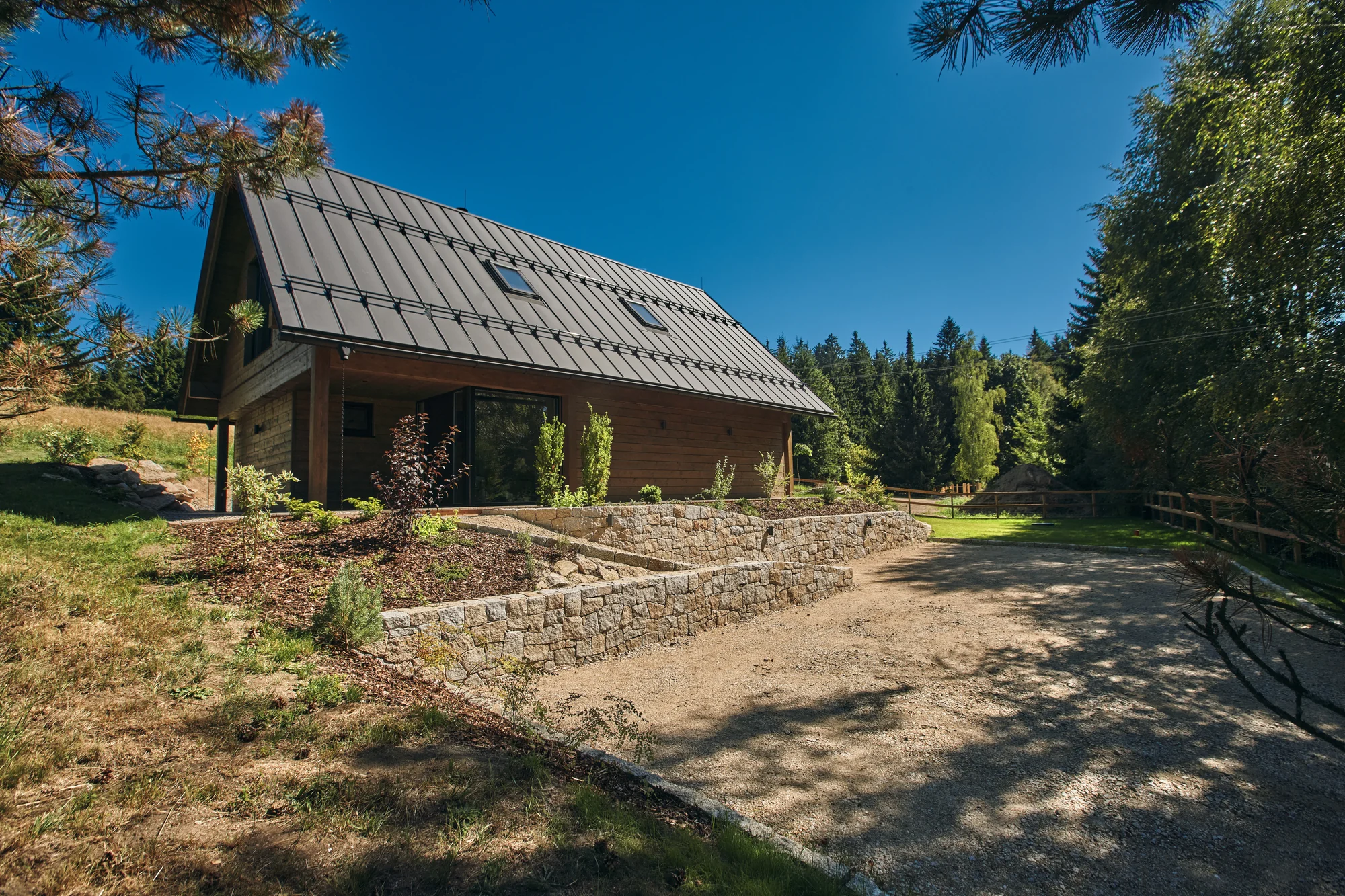 Příjezd k chaletu, kamenné zídky a upravená zahrada